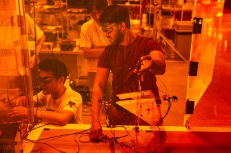 Researchers are working on the Areobat robot in an orange-colored laboratory.