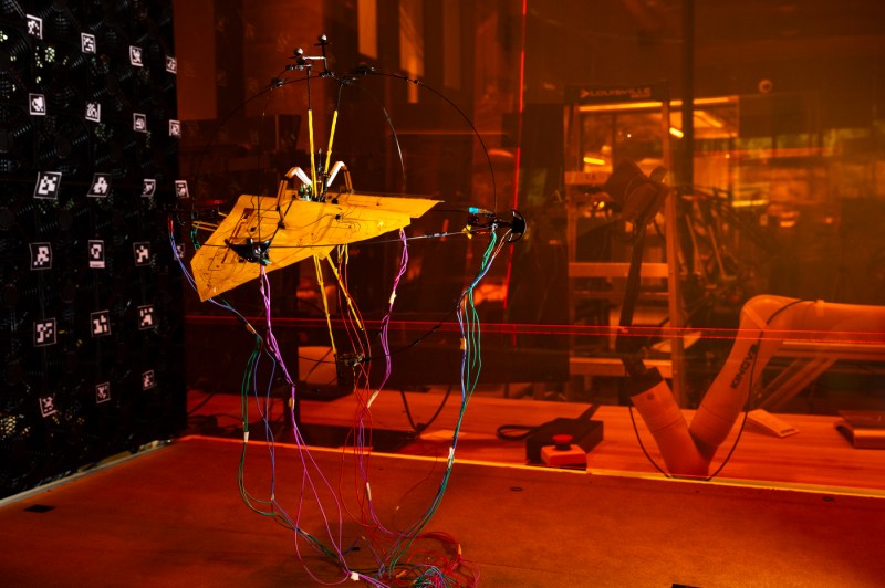 An Aerobat robot in a lab that is lit with orange lighting.