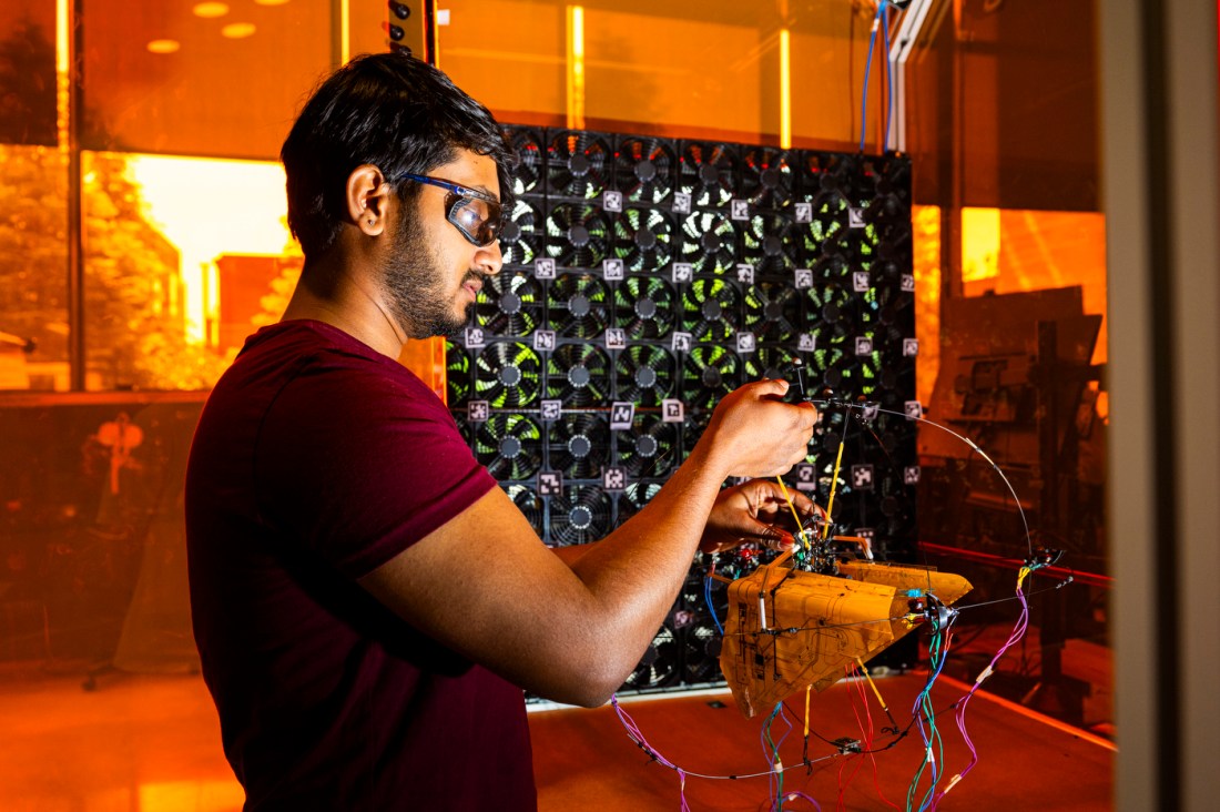 A student working on a flying bat robot in an EXP lab.