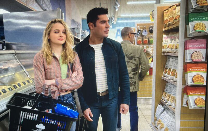 Zac Effron and Joey King shop in a grocery store next to a row of AshaPops.