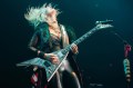 Britt Lightning throws her head back while playing the guitar on stage.