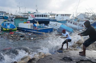 People caught in Hurricane Beryl trying to pull their boat to the shore.