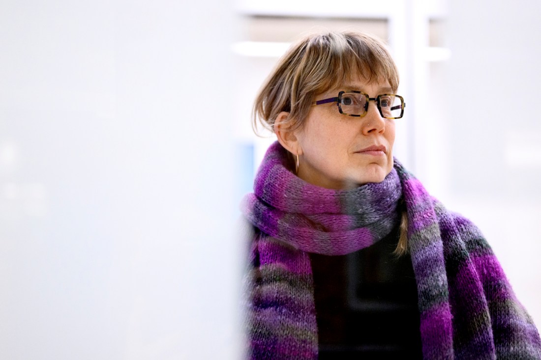 Headshot of Julia Hechtman, wearing a purple scarf, on a white background.