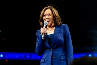 Kamala Harris speaks into a microphone while she stands on stage.