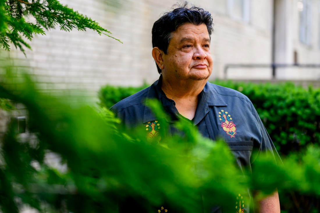 Ramiro Martinez, Northeastern professor of sociology and criminology and criminal justice, poses against a landscape of trees for a portrait. 