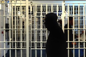 The silhouette of a person in a jail cell.