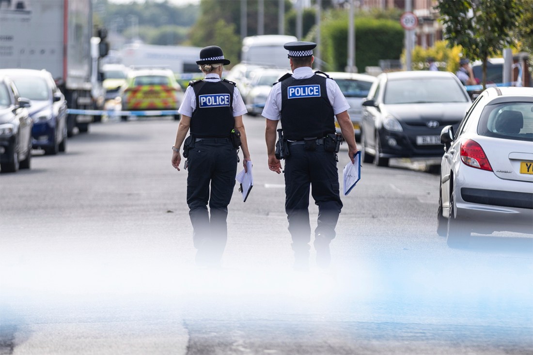 Two police officers walking down the street in Southport.