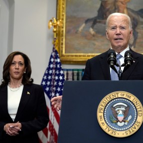 Joe Biden speaking at a microphone with Kamala Harris standing in the background.