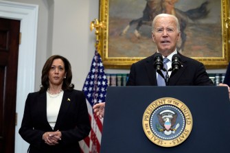 Joe Biden speaking at a microphone with Kamala Harris standing in the background.