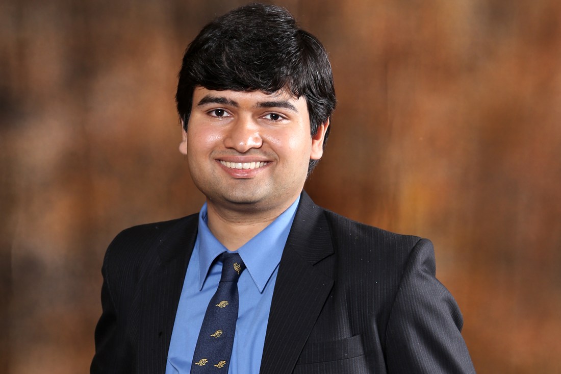 Smiling headshot of Aditya Mishra, wearing a suit and tie.