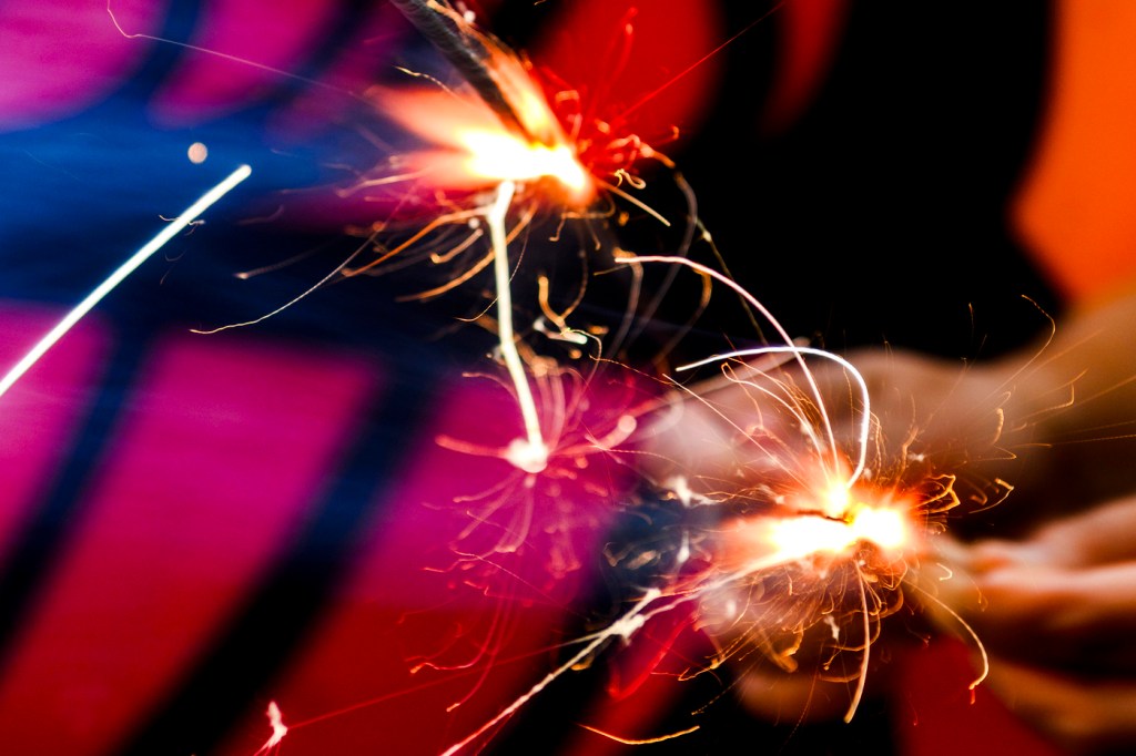 Hands holding firecrackers.