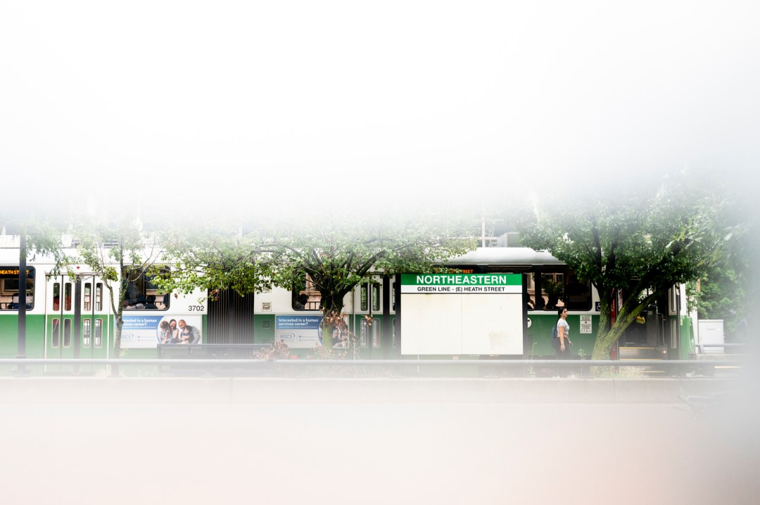 A white, blurry haze designed around an image of a person walking past train trains.