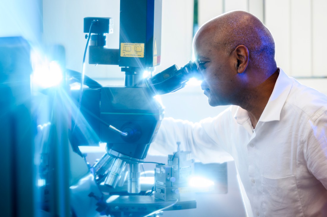 Srinivas Tadigadapa looking through a microscope.