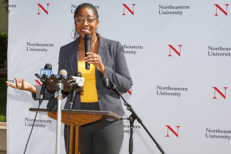 A person speaking into a microphone at the Oakland Opportunity Scholarships press conference.