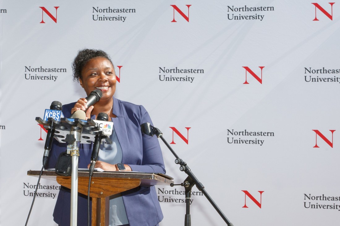 A person speaking into a microphone at the Oakland Opportunity Scholarships press conference.