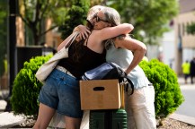 A student hugging their family.