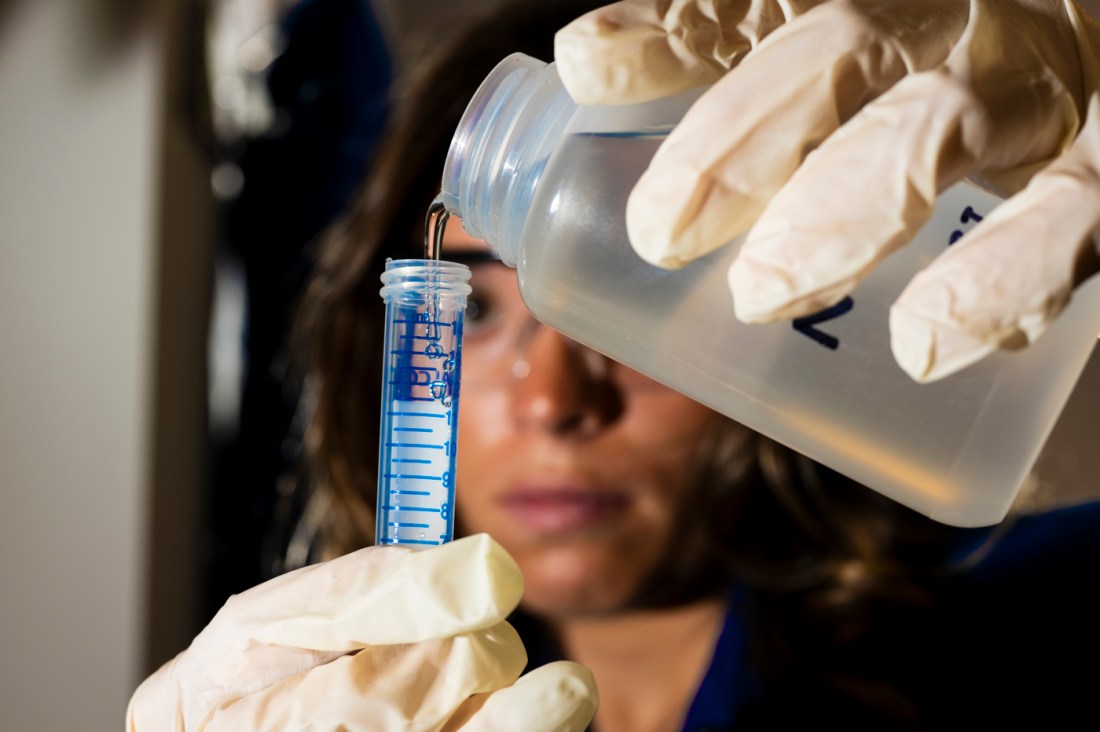 Kyla Drewry pouring test water into a test tube.