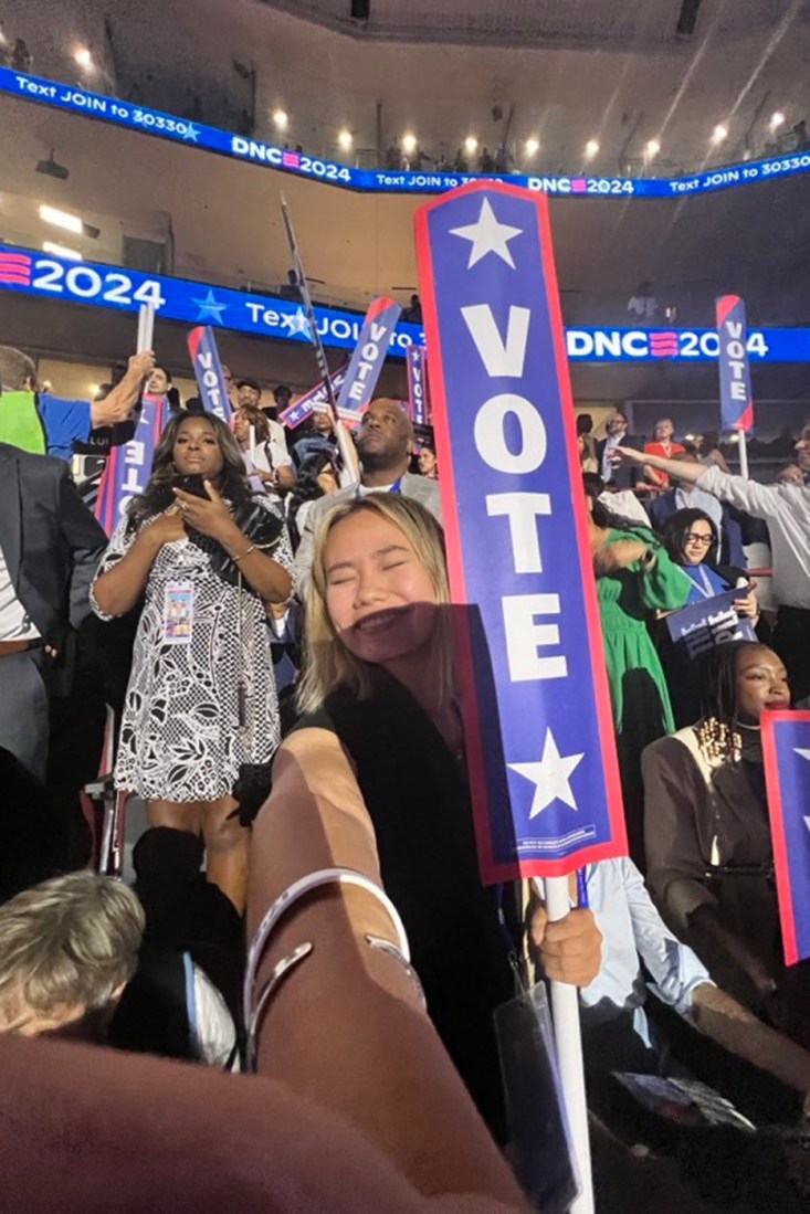 A selfie of Claire Satkiewicz holding a 'Vote' sign at the DNC.