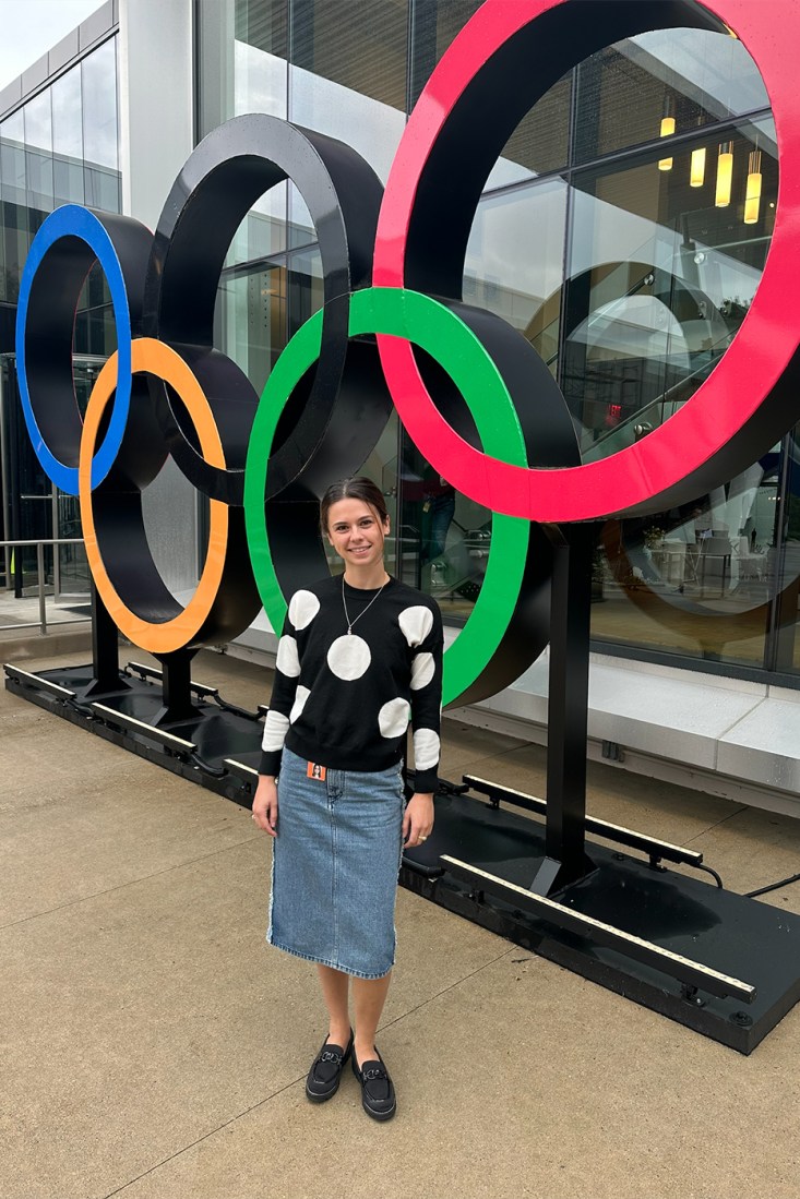 Claire Dudley in front of Olympics logo. 