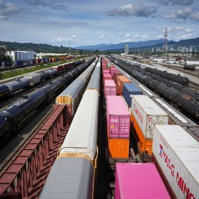 Shipping containers and rail cars at a rail yard in Canada.