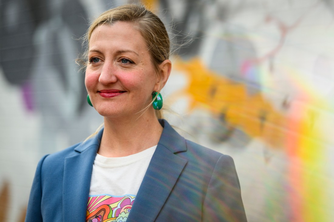 Portrait of Rebekah Moore, outside in front of colorful art.