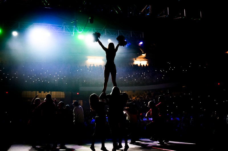 Silhouette of cheerleaders on stage at Convocation.