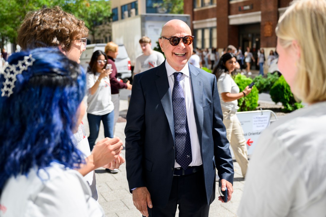 President Aoun smiling and laughing with a group of students.