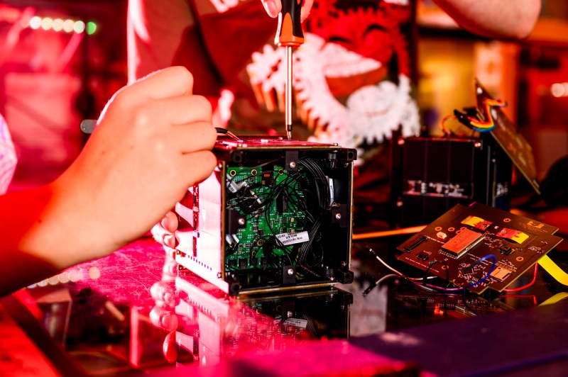 A student working on a test box with a screwdriver. 