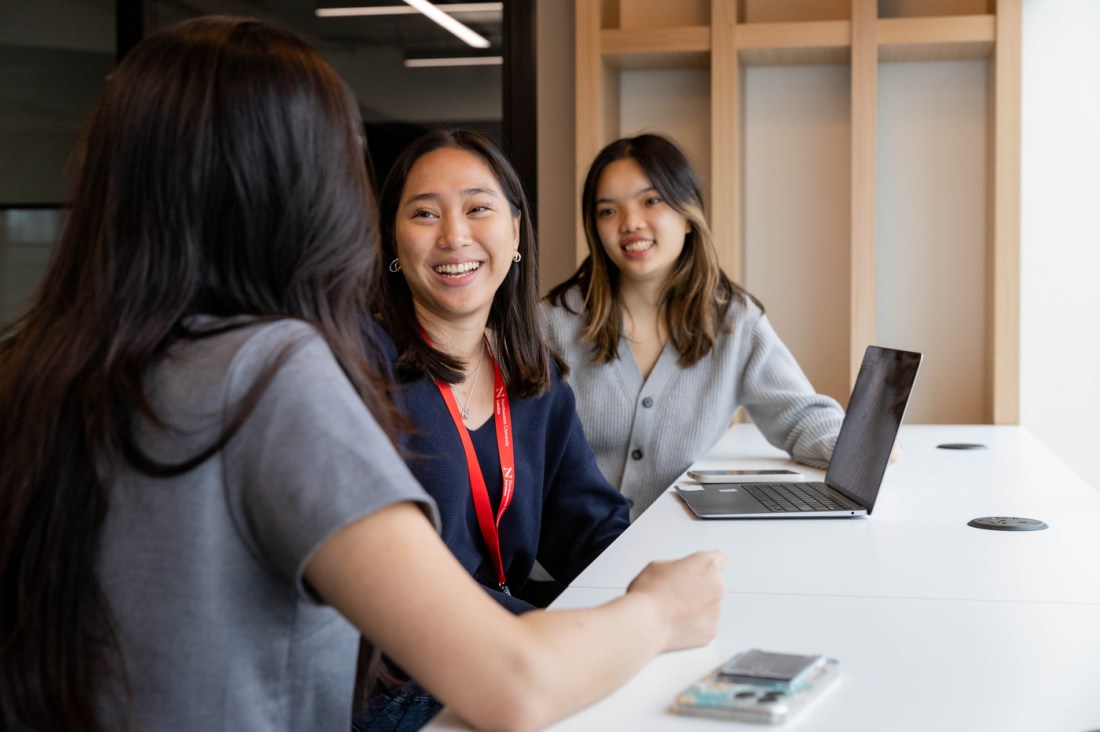 Three students talking and laughing in One Portsoken building.