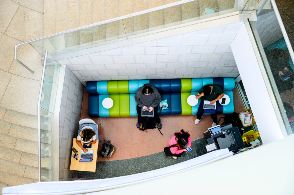 A view from above of students studying on a couch and at tables.