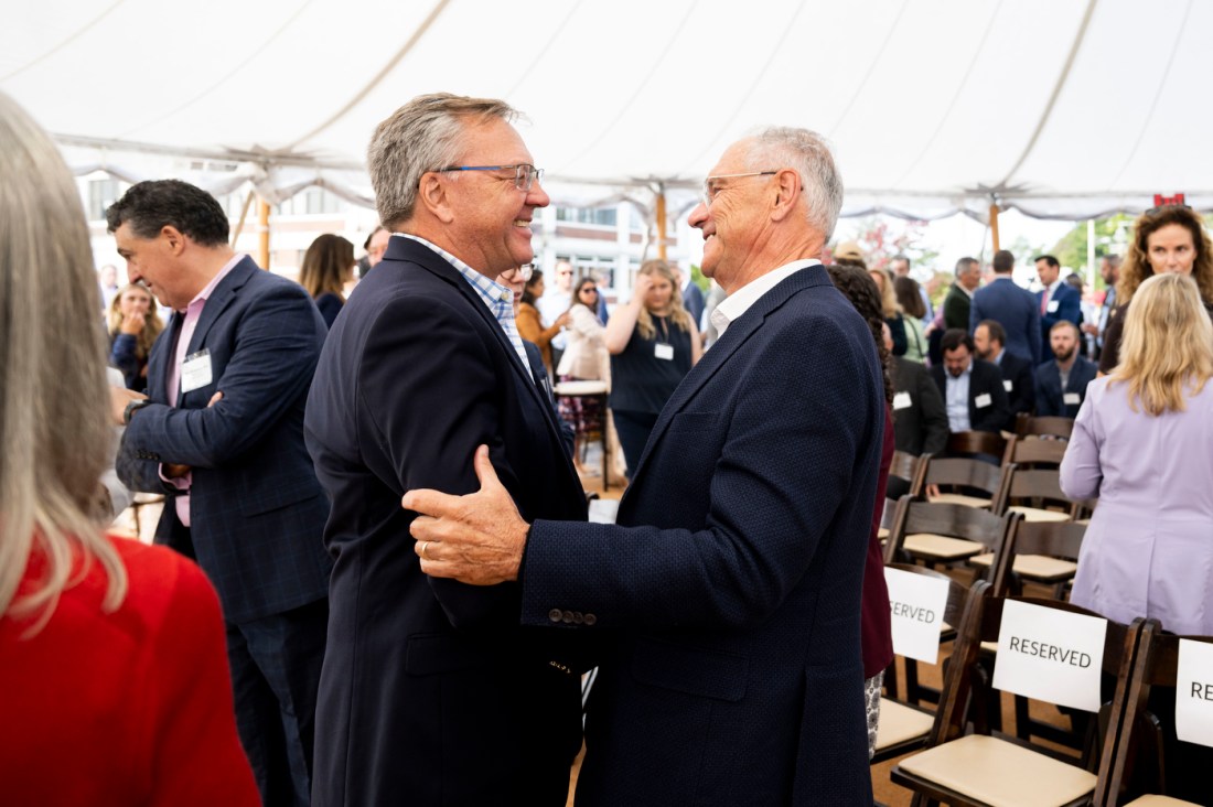 Two people greeting each other at the Portland ground breaking. 