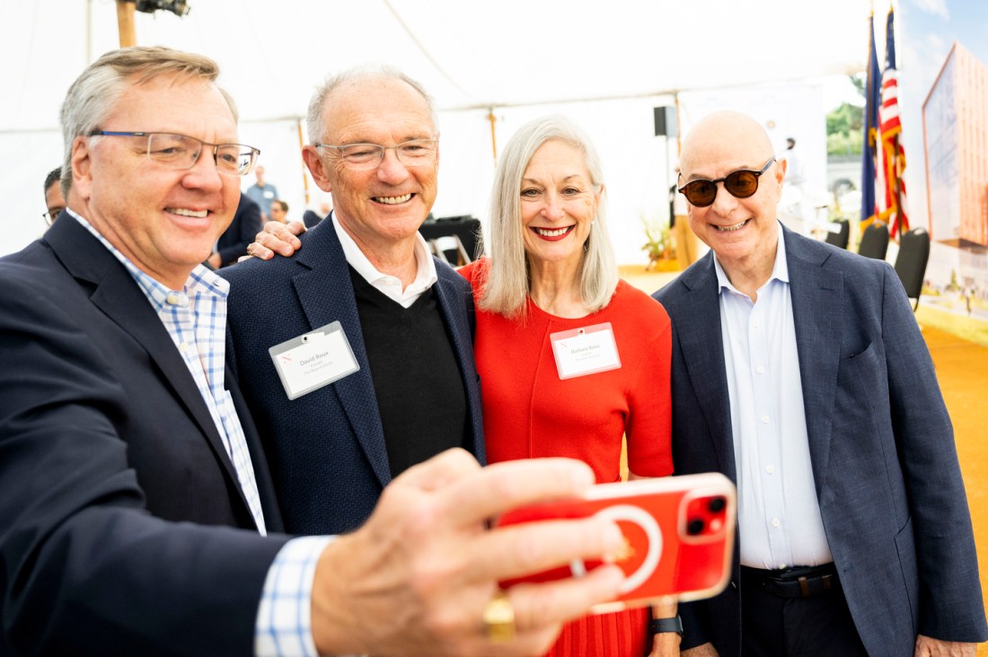 A person takes a selfie with David and Barbara Roux and President Aoun. 