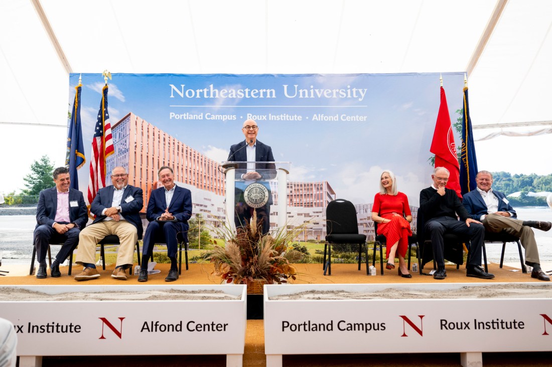 President Aoun standing at a podium for the Portland campus ground breaking.