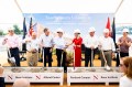 A group of people wearing hard hats and holding shovels at the Portland campus ground breaking.