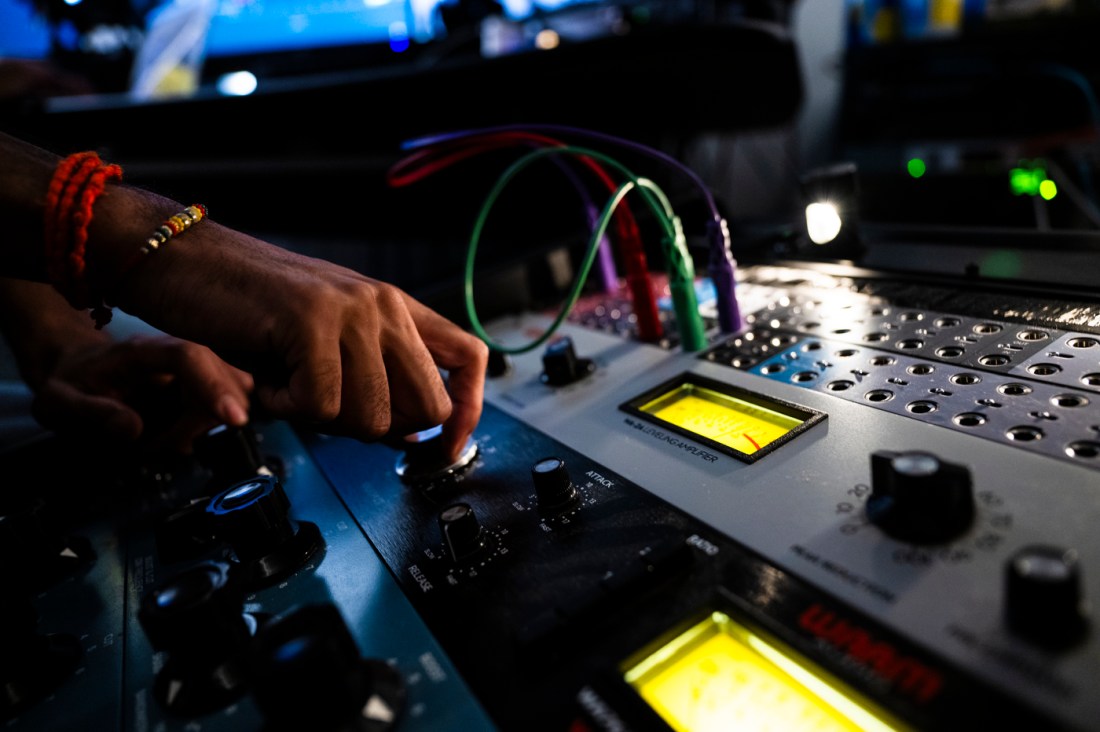 A person turning a dial while laying tracks for a record. 