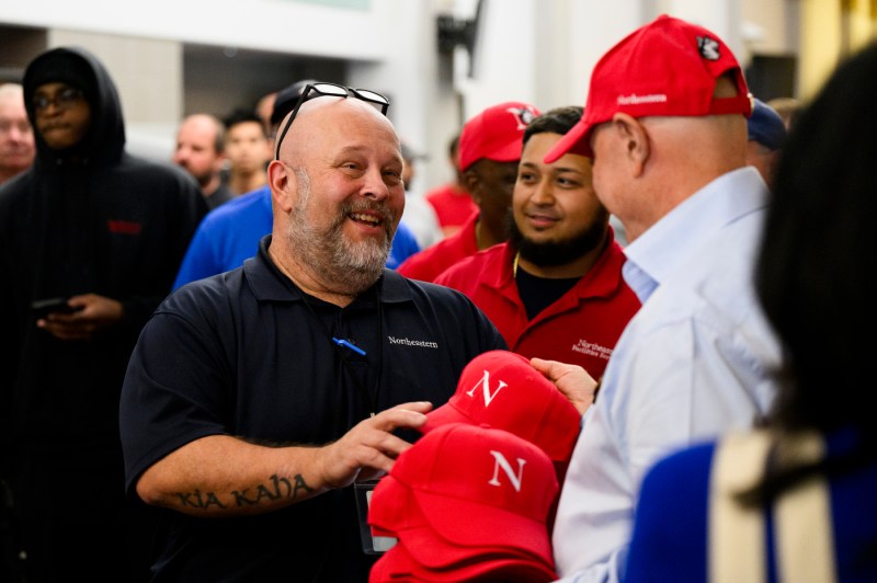 President Aoun passing out red baseball caps at the facilities BBQ.