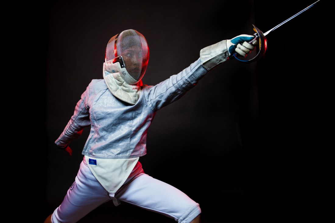 Sabrina Balmaseda in fencing gear lunging forwards with her sword.