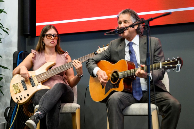 Daniel Levitin playing a guitar on stage with another person. 