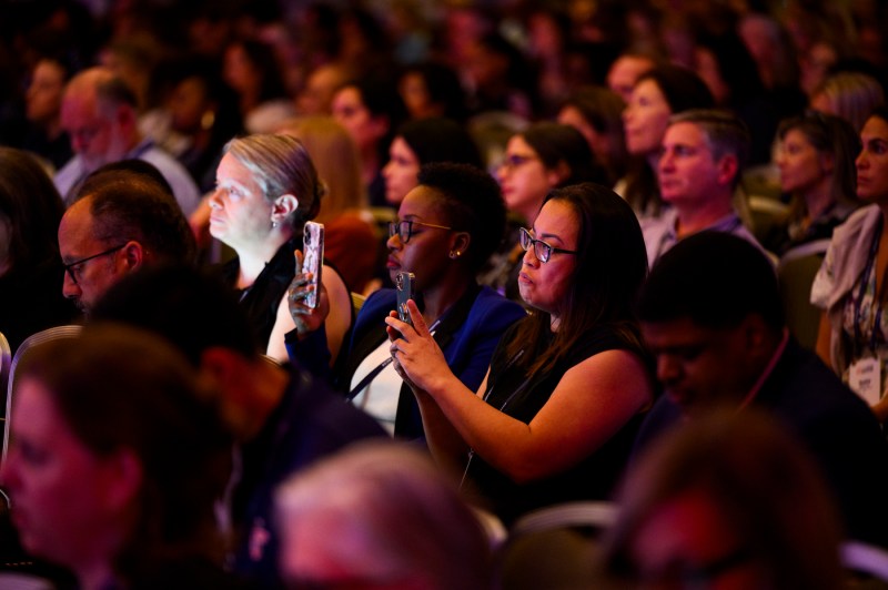 Audience members using their phones to photograph and record.