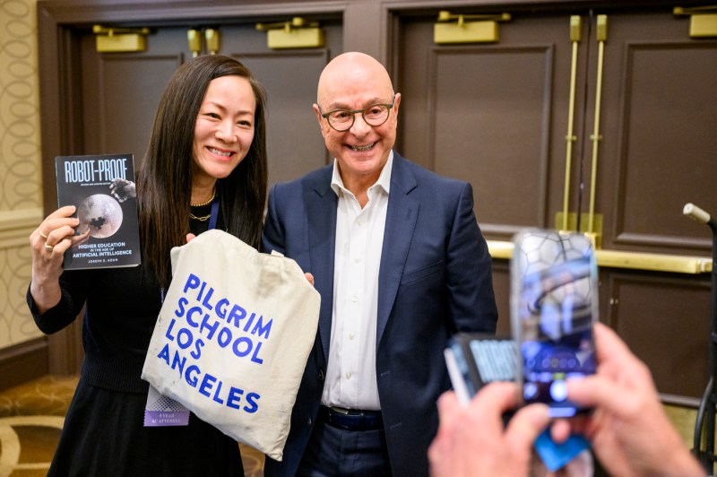 President Aoun poses with a person holding a copy of his book, 