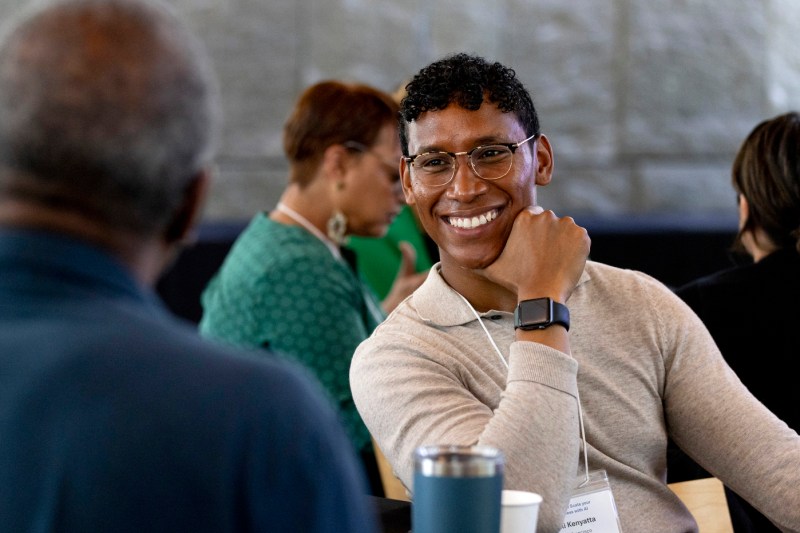 Suli Kenyatta smiling while talking to another person at the AI workshop.