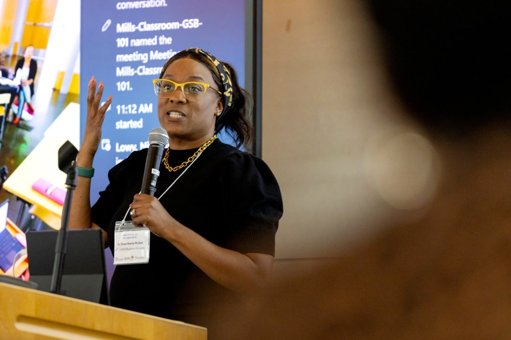 Dr. Dene' Starks-McGee speaking into a microphone during the AI workshop.