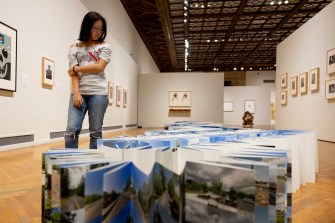 A person looking at an art exhibit in the center of a room at the Mills College Art Museum.