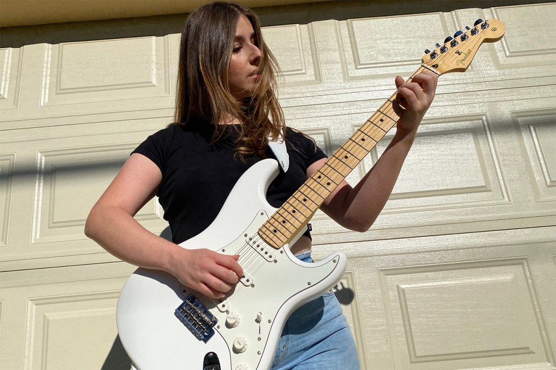 Annie Schindel playing a white electric guitar.