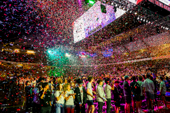 Students with their hands in the air as confetti falls around them at Convocation.