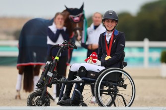 Fiona Howard sitting in a wheelchair next to her horse.