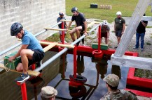 Students wearing bicycle helmets crossing an obstacle course.