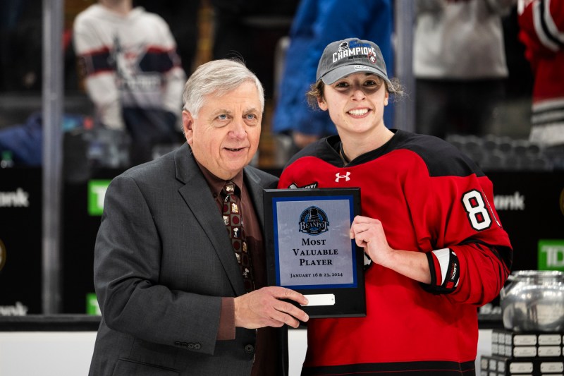 Skyer Irving posing with another person and a plaque.