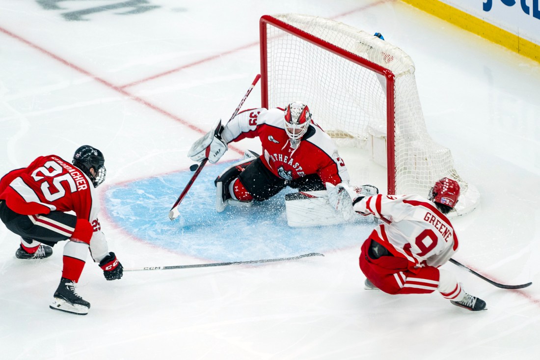 Hockey players battle for the puck on the ice.