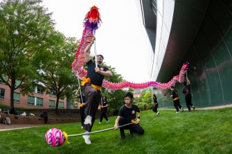 Performers interact with a large, colorful prop during an outdoor routine.